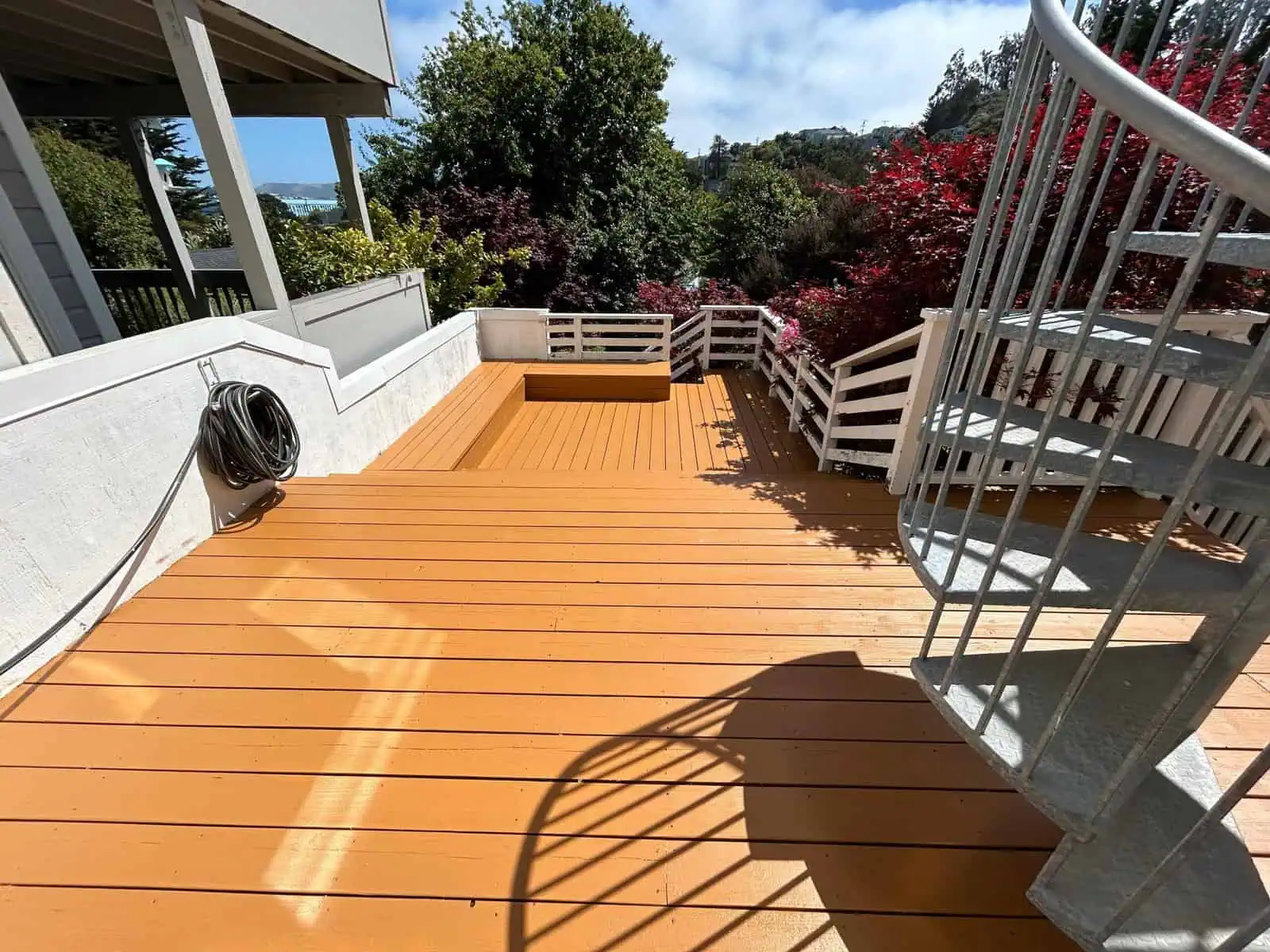 Deck with wooden planks, metal railing, and scenic outdoor surroundings.