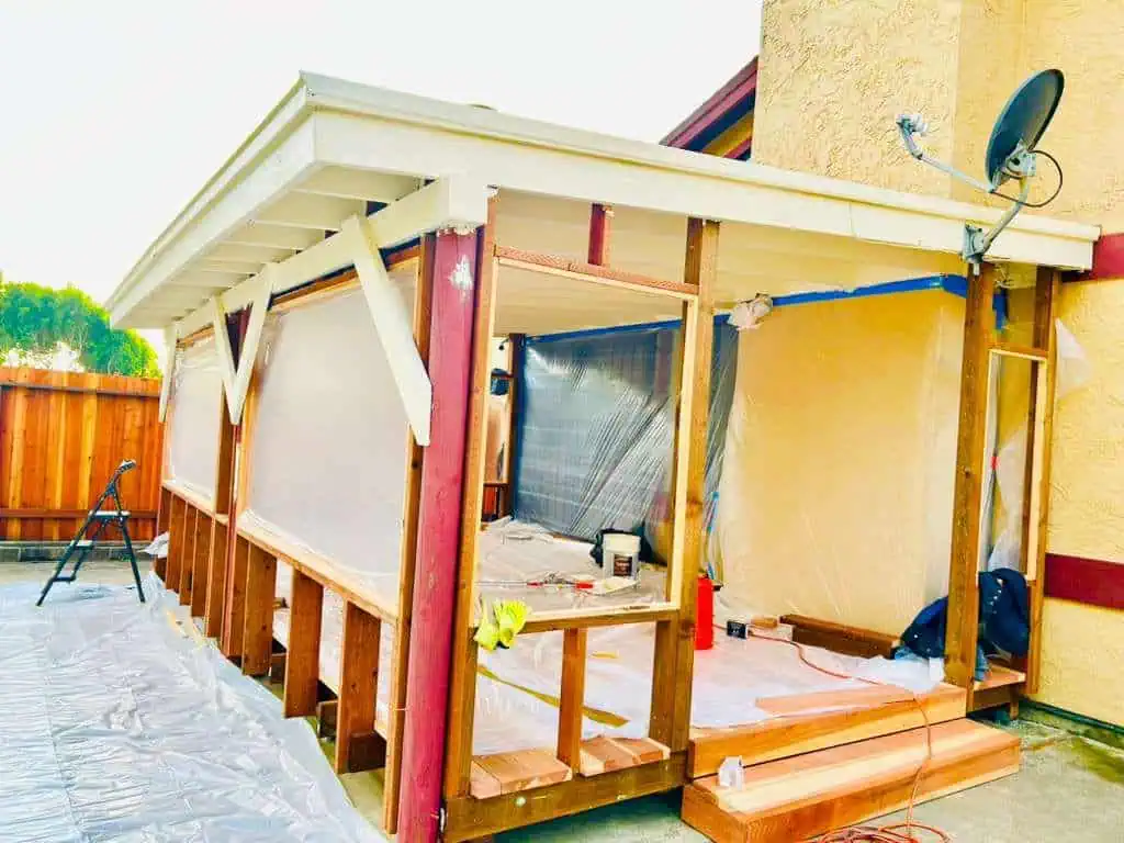 Custom porch construction with wooden framing and roofing by ISMA BUILDERS.