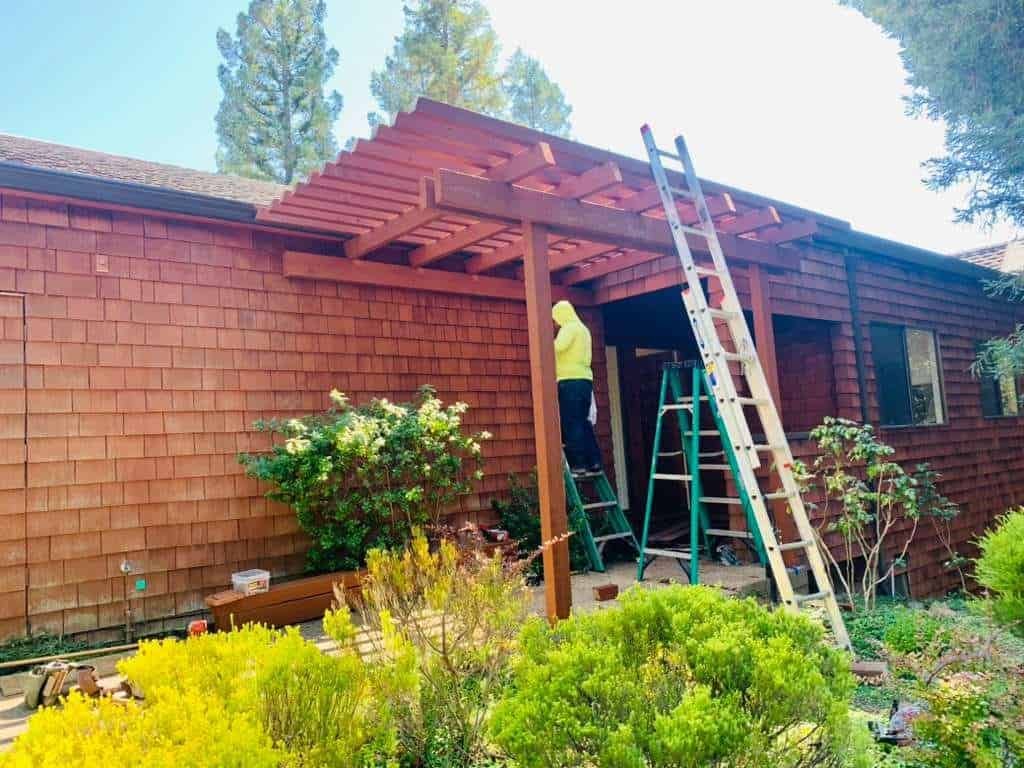 Custom home exterior construction with wooden porch and ladder, showcasing ISMA BUILDERS' craftsmans.