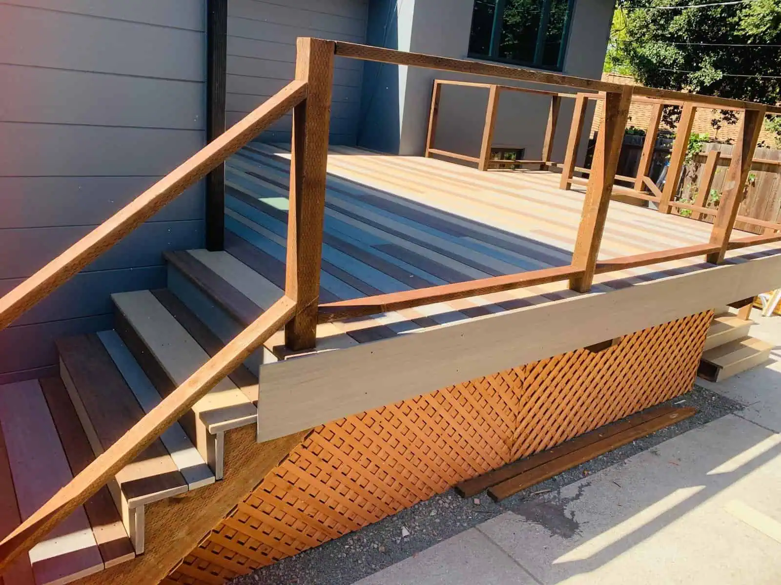 Wooden deck with stairs and safety railing, ideal for outdoor living spaces.